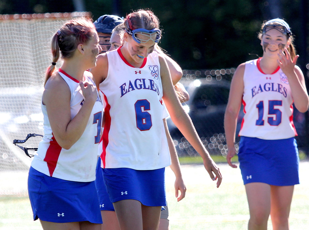 Messalonskee High School’s Lydia Dexter, left, and Ally Turner, 6, walk off the field after the Eagles sank Portland 11-8 in the Eastern Maine Class A girls' lacrosse championship Wednesday at Thomas College in Waterville. Jenna Nash is at far right. The team members wore a “CC” patch on their jerseys this spring to honor late teammate Cassidy Charette, who was killed in an Oct. 11 hayride accident.