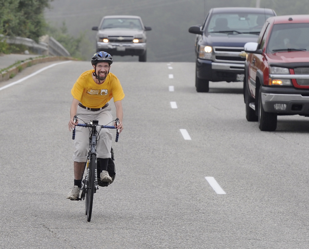 John Brooking “controls the lane” near the Maine Mall in South Portland. He and other bicycle educators say riding near the middle of the road is sometimes necessary for safety.