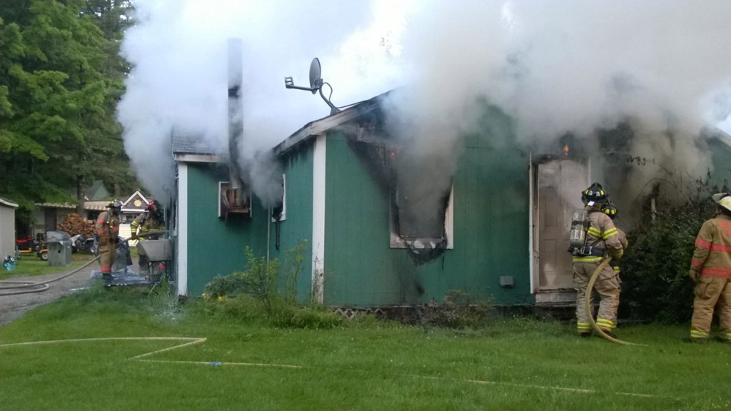 Firefighters work to extinguish a fire at a single-family home on Post Road in Bowdoinham on Thursday.