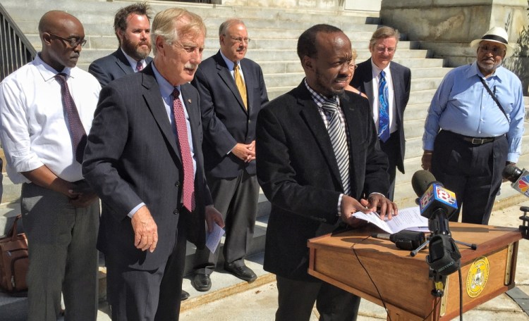 Sen. Angus King listens as Philemon Dushimire talks about the hardships he faced as an asylum seeker in Maine without a work permit.