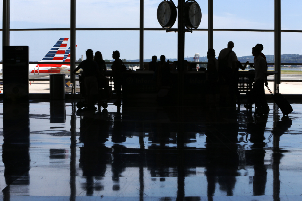 People ask questions at an information kiosk at Washington’s Reagan National Airport after technical issues at a Federal Aviation Administration caused delays and cancellations on Saturday.