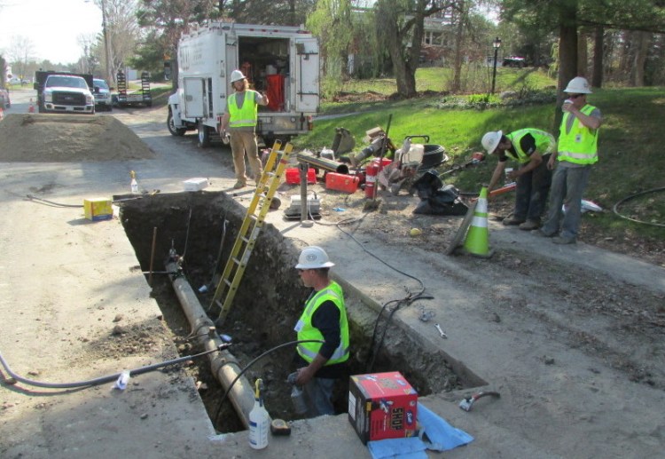 Employees of ETTI, a utilities construction company from Lisbon Falls, work on a Summit Natural Gas line on Cool Street in Waterville in May. The company is scaling back its Kennebec Valley build-out.