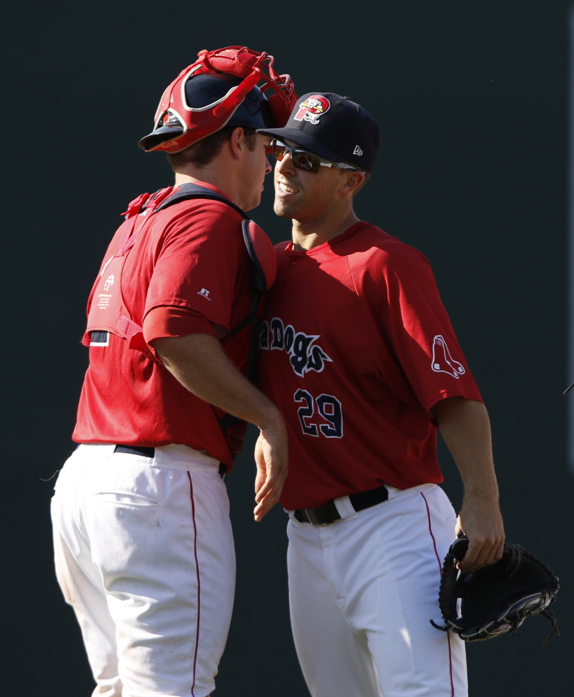 Sea Dogs Cole Sturgeon, right, hugs catcher Danny Bethea after their game Monday against the Rock Cats in Portland.