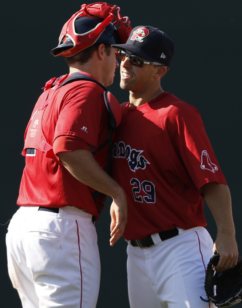 Cole Sturgeon, right, and Danny Bethea hug as the Sea Dogs end their season on a high note Monday, beating New Britain 10-4. The Sea Dogs suffered through a franchise-worse 53-89 season.