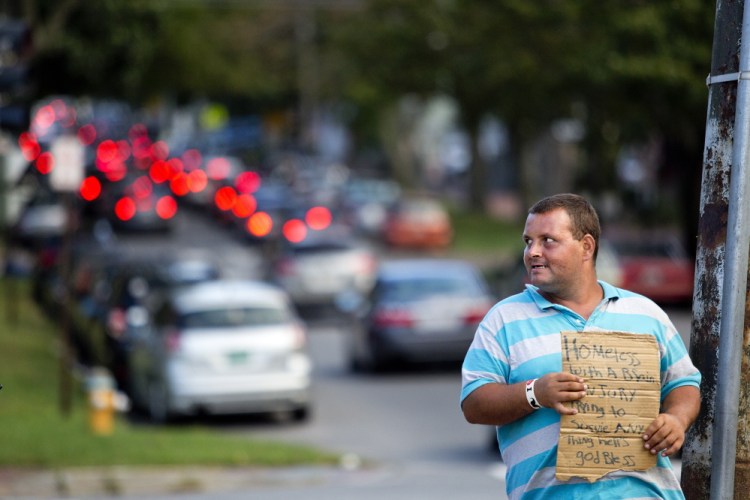 Louis Walker, 32, of Portland, panhandles for money at the corner of State Street and Park Avenue on Friday evening. Walker, who lives with his wife in a tent in the woods, says he’s been panhandling for about three weeks. “I’m glad they’re keeping it legal,” he said.