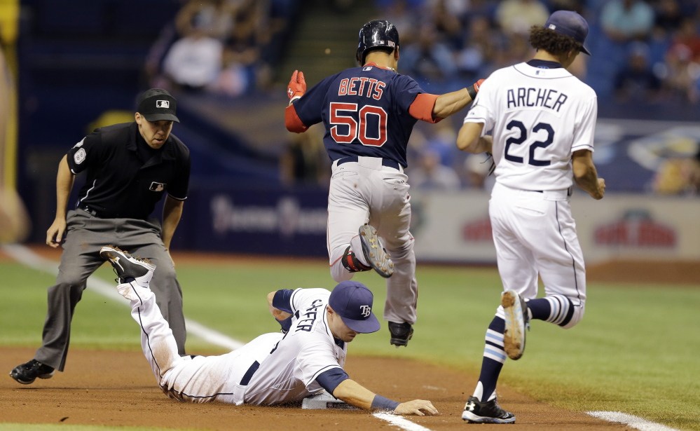 Rays first baseman Richie Shaffer dives and beats Red Sox center fielder Mookie Betts to first on a ground out in the first inning Friday in St. Petersburg, Fla.  Backing up the play is starting pitcher Chris Archer.