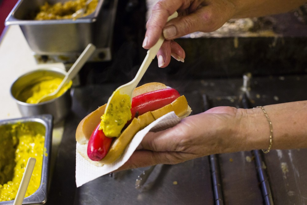 A hot dog is dressed upon assembly at Vivian’s Drive-In on Forest Avenue in Portland. The establishment is for sale.