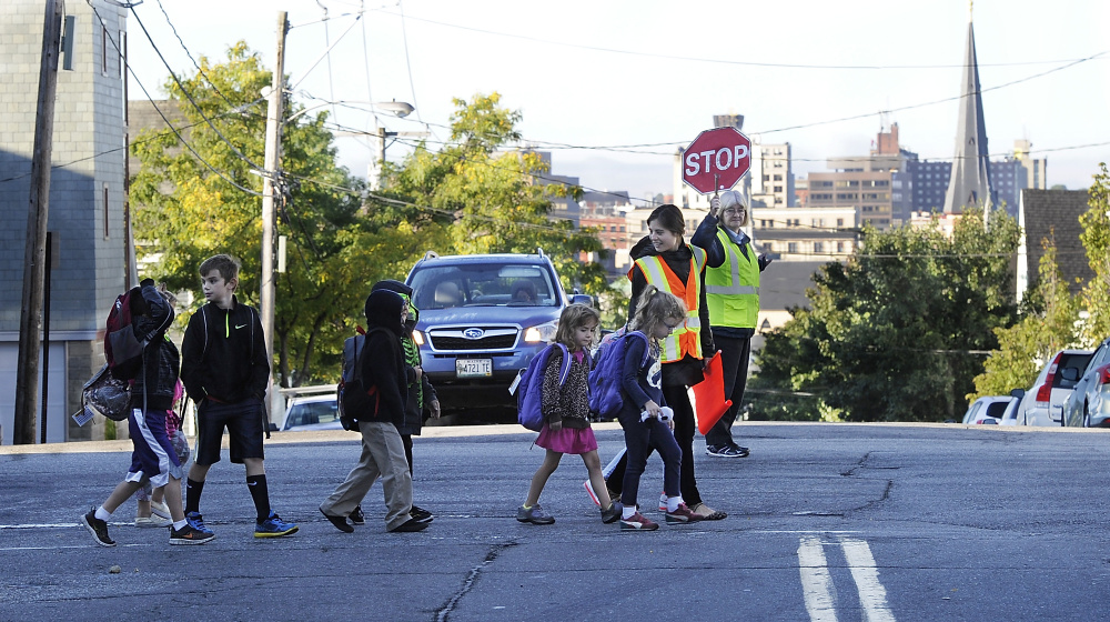 Elise Moody-Roberts shepherds the Walking School Bus across Cumberland Avenue at North Street.