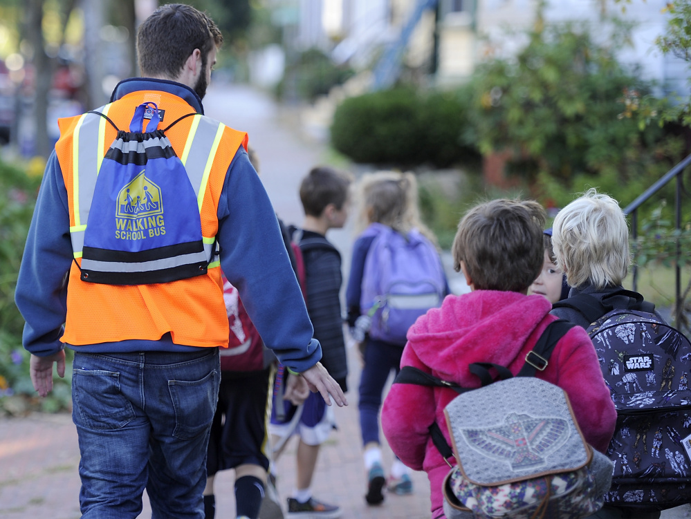 Volunteer Stephen McLeod wears the Walking School Bus backpack as he leads the group to East End Community School.