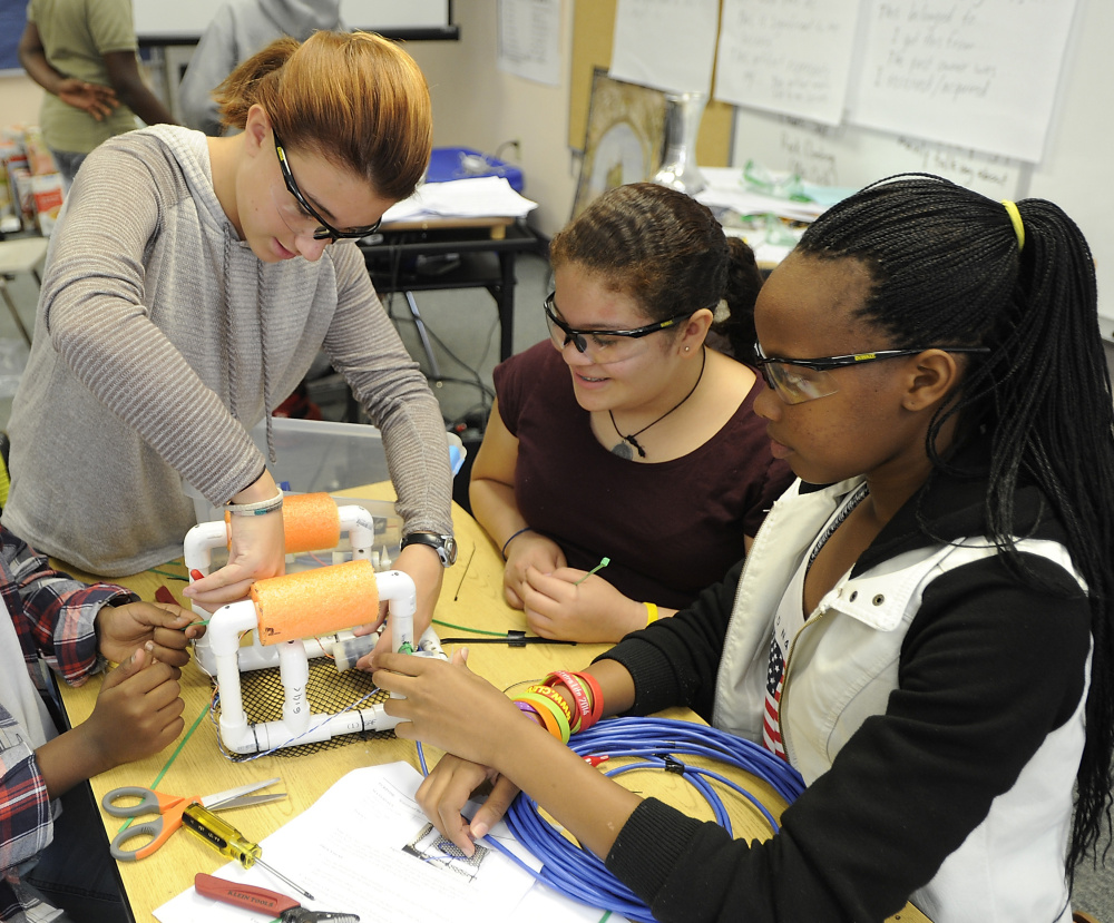 Audrey Watson, 11, left, helps her  classmates attach the wires to the motors on their submersibles.