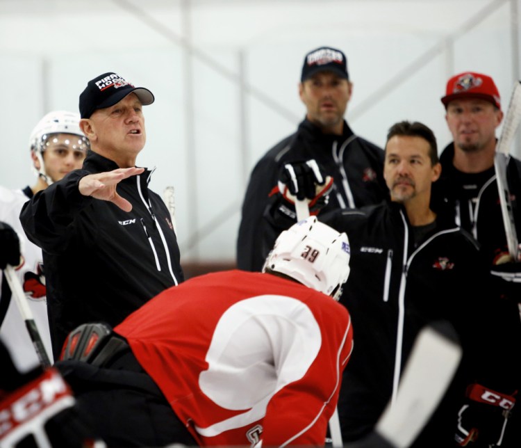 Portland Pirates Coach Tom Rowe, left, and his assistant, Scott Allen, second from right, bring a winning history to the Pirates.