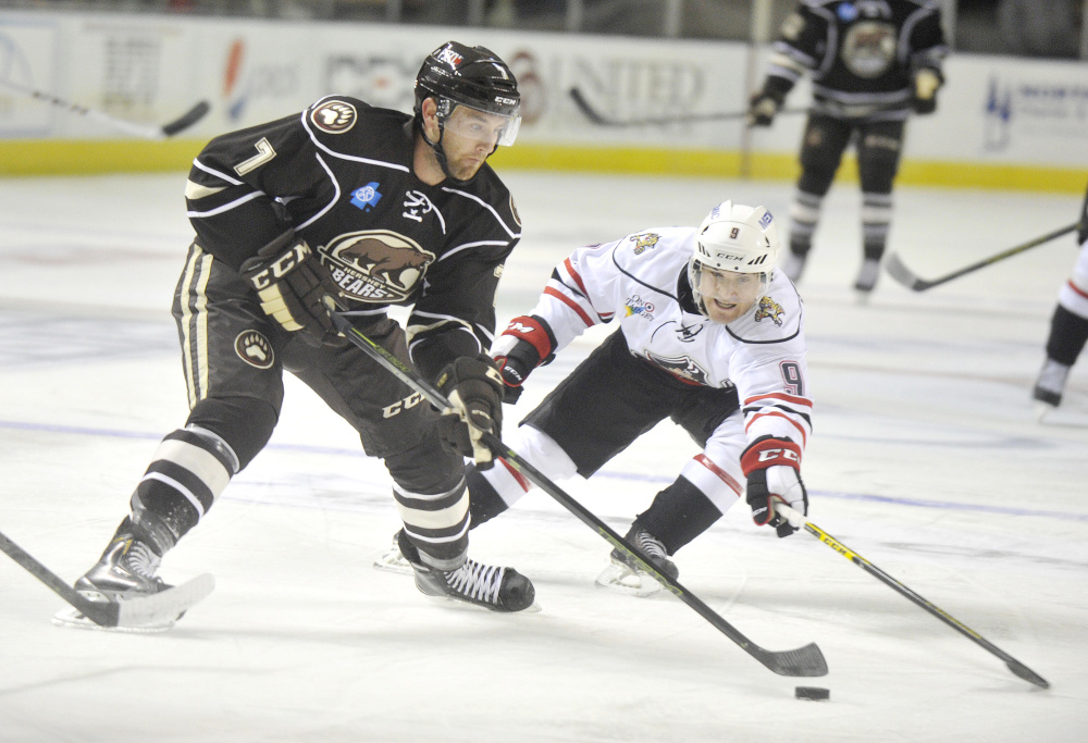 Hershey’s Ryan Stanton carries the puck while being defended by Portland’s Rocco Grimaldi during the Pirates’ home opener on Saturday in Portland.