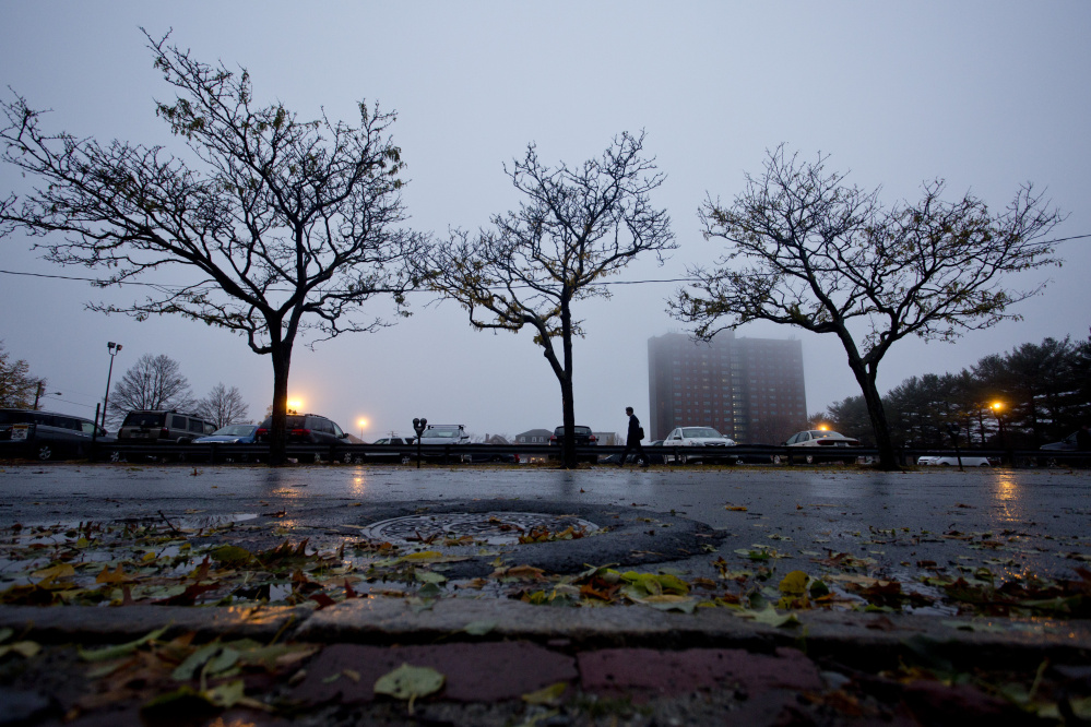A man walks along Congress Street on Thursday after an overnight storm pounded much of southern Maine.