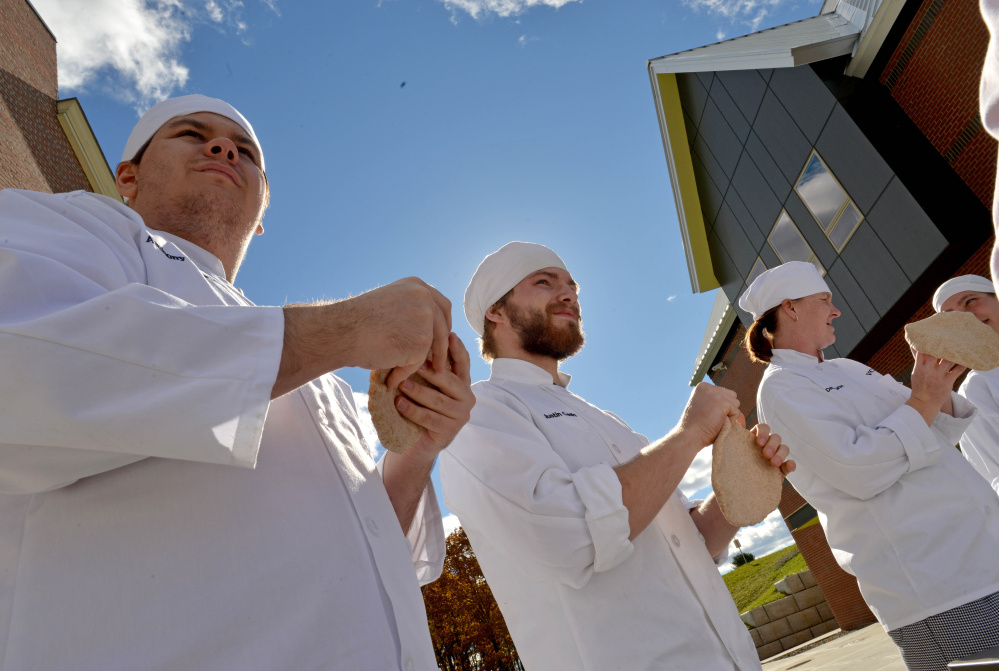 Culinary students at Kennebec Valley Community College, from left to right, Anthony Casoria, Justin Cash and Denise Barton, prepare pizza dough as they fire up the wood-fired oven for class at the Alfond campus on Friday.