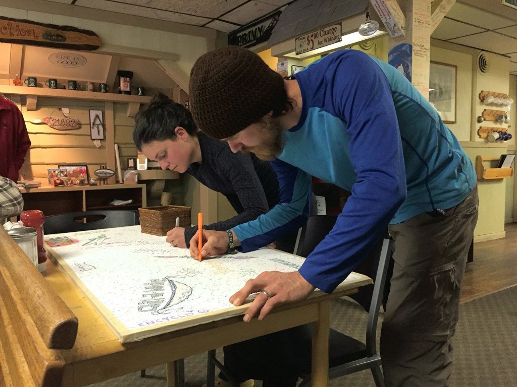 Two hikers who completed the roughly 2,190-mile Appalachian Trail on Friday – Jimi "Fuego" Williams and Christy "Fancy Pants" Williams of Richmond, Va. – sign their trail names on a ceiling tile in the Appalachian Trail Cafe in Millinocket, following a tradition for many successful thru-hikers. The Williamses said the tension caused by a small number of thru-hikers who flout Baxter State Park rules was a topic of conversation among hikers on the trail.