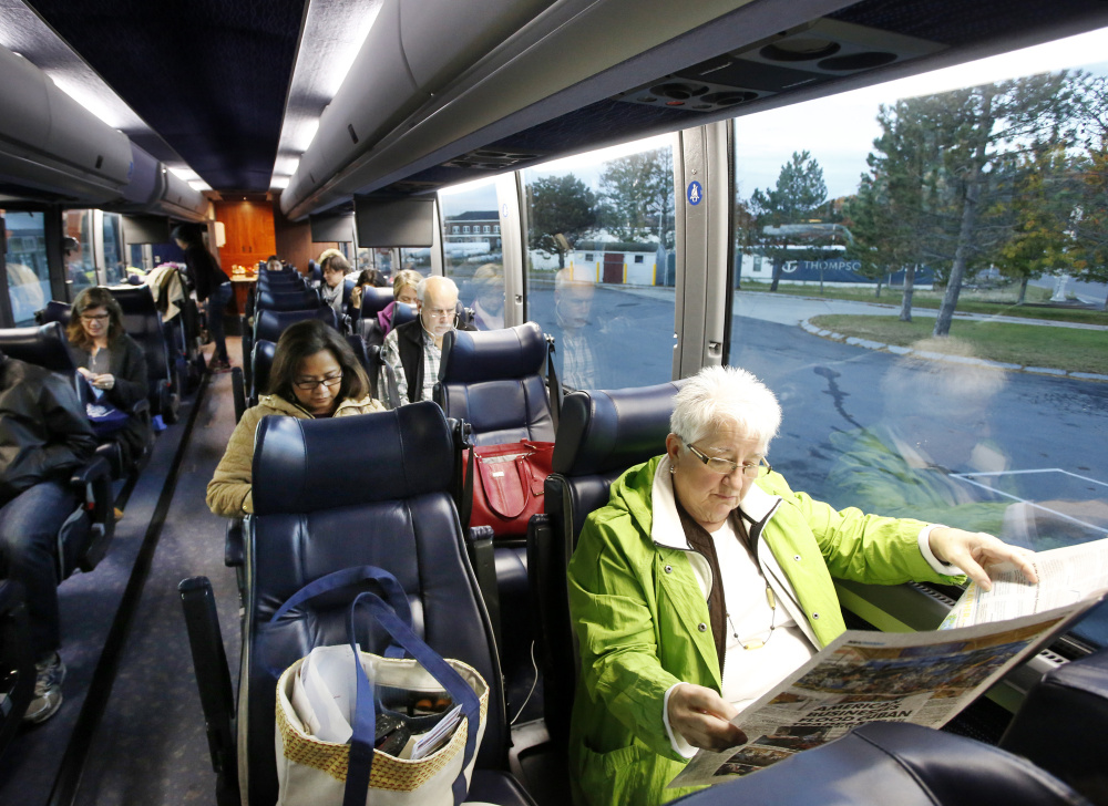 Karen Roen of Waldoboro reads a paper while waiting to depart from the Portland Transportation Center for New York City on Monday morning.