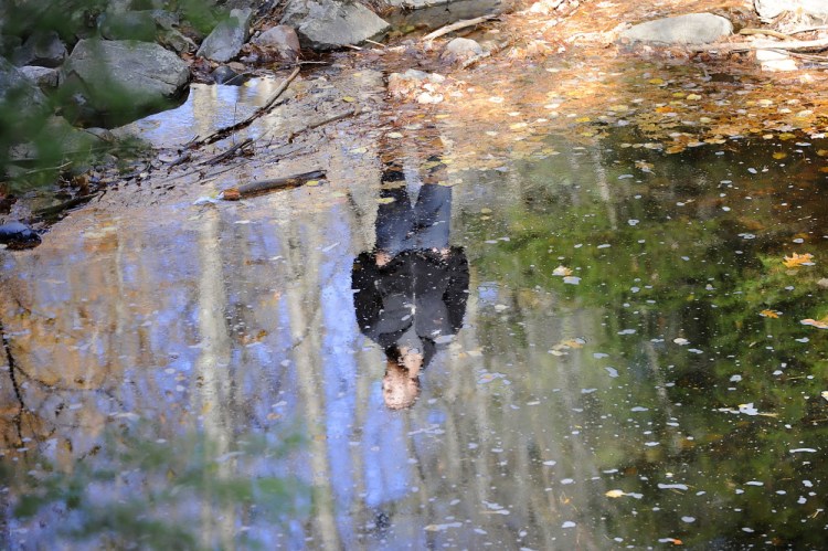 UNE student Alec Batcheller is in a reflective mood at a pond in Clifford Park as he joins classmates for an educational walk through the preserve.