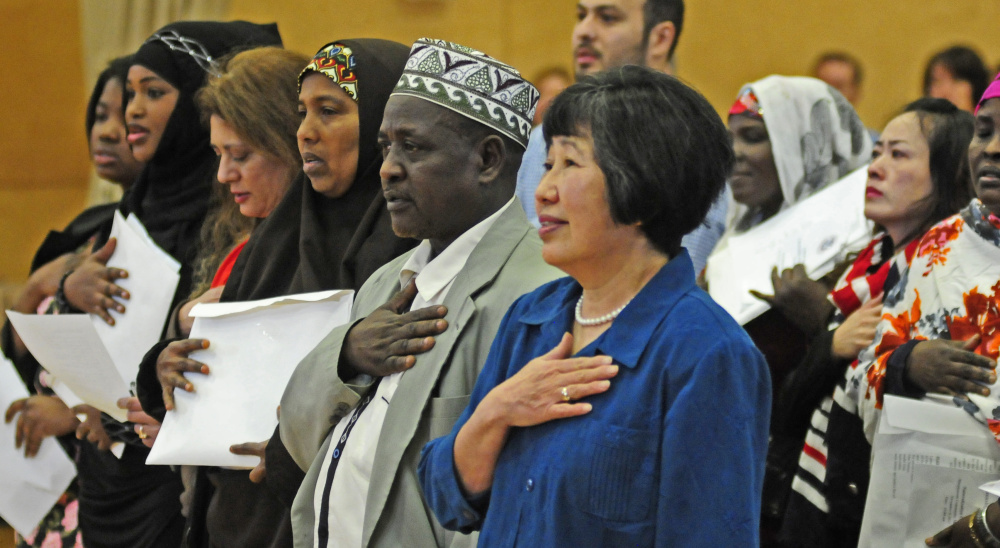 New American citizens recite the Pledge of Allegiance during a naturalization ceremony Friday at Maranacook Community Middle School in Readfield.