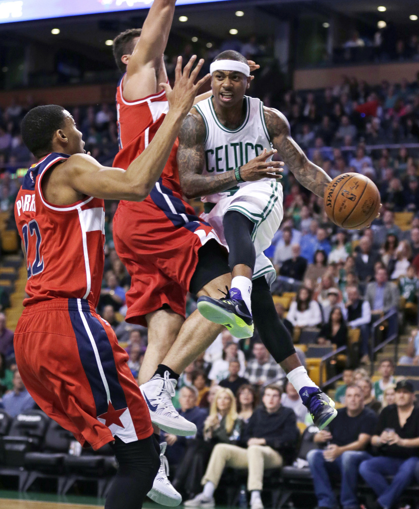 Celtics guard Isaiah Thomas looks to pass as he is covered by Washington forwards Otto Porter Jr. (22) and Kris Humphries in the first quarter. Thomas finished with 16 points and eight assists.