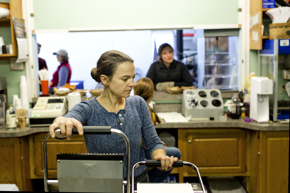 Jenn Legnini of Brunswick mans the panini press at Midcoast Market Cafe at the Winter Farmer's Market at the Topsham Fairgrounds.  Gabe Souza/Staff Photographer