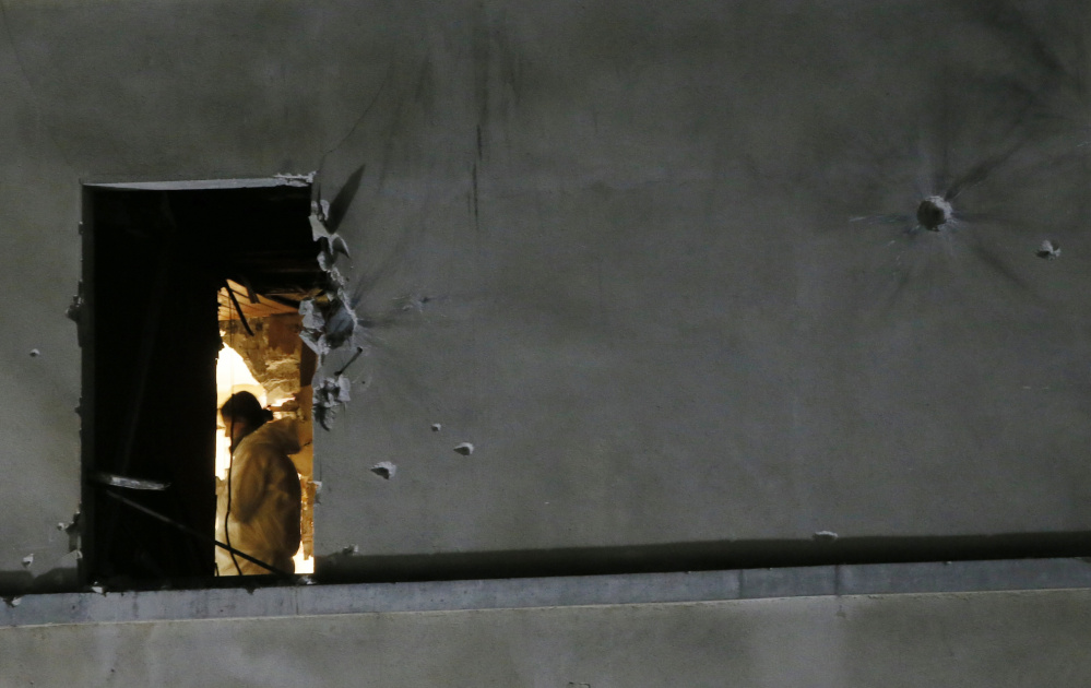 A forensics expert inspects the apartment raided by French special forces Wednesday in Saint-Denis, a Paris suburb, as police pursued suspects in last week’s terror attacks.