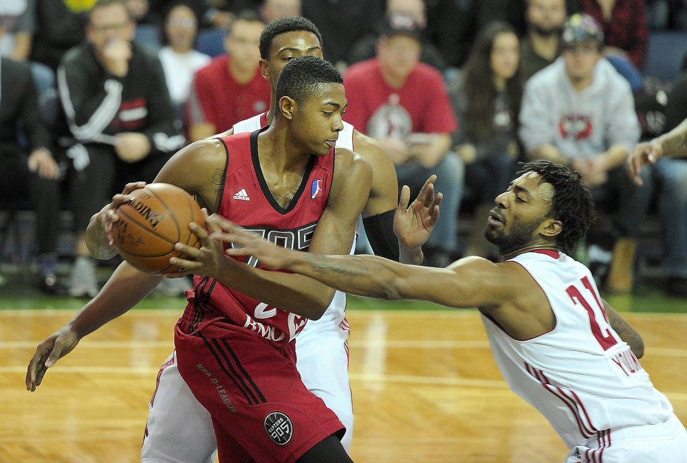 Raptor 905 forward Bruno Caboclo gets trapped between Red Claws forward Jordan Mickey and guard James Young at the Portland Expo on Friday.