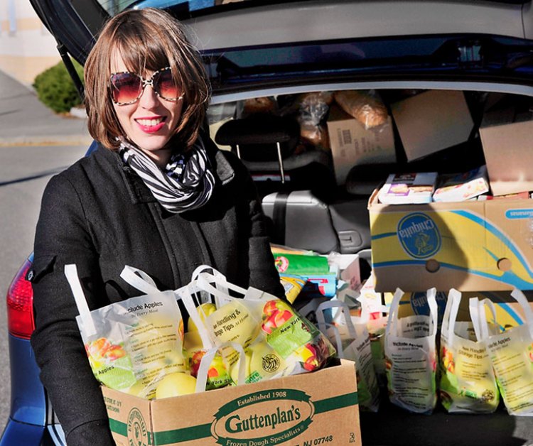 Katie Wallace delivers snacks to the East End Community School in Portland last week. It’s not charity, says the parent volunteer; “It’s about community.”  Gordon Chibroski / Staff Photographer