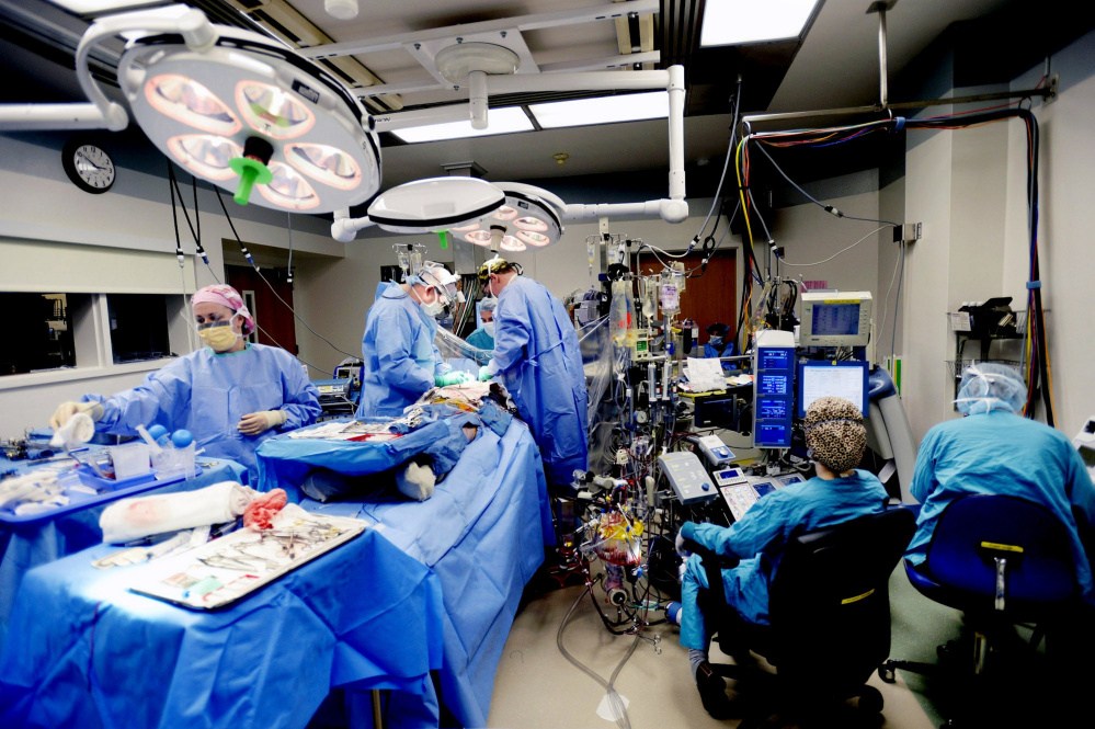A surgery takes place last year in a crowded operating room at Maine Medical Center. New federal figures show spending on health care rose more in Maine than the nation as a whole from 2004 to 2014, from $4,727 to $7,289 per person, probably because of the state’s older population.