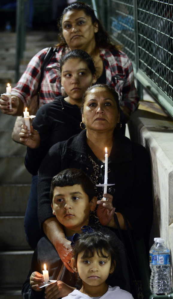 Elda Flores, center, and her family attend a vigil in San Bernardino, Calif., for victims of the shootings there. Gun violence claims over 30,000 lives a year in the U.S.