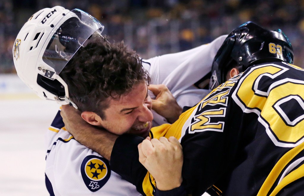 Nashville Predators defenseman Roman Josi, left, loses his helmet as he fights Boston Bruins left wing Brad Marchand (63) during the second period. (AP Photo/Charles Krupa)