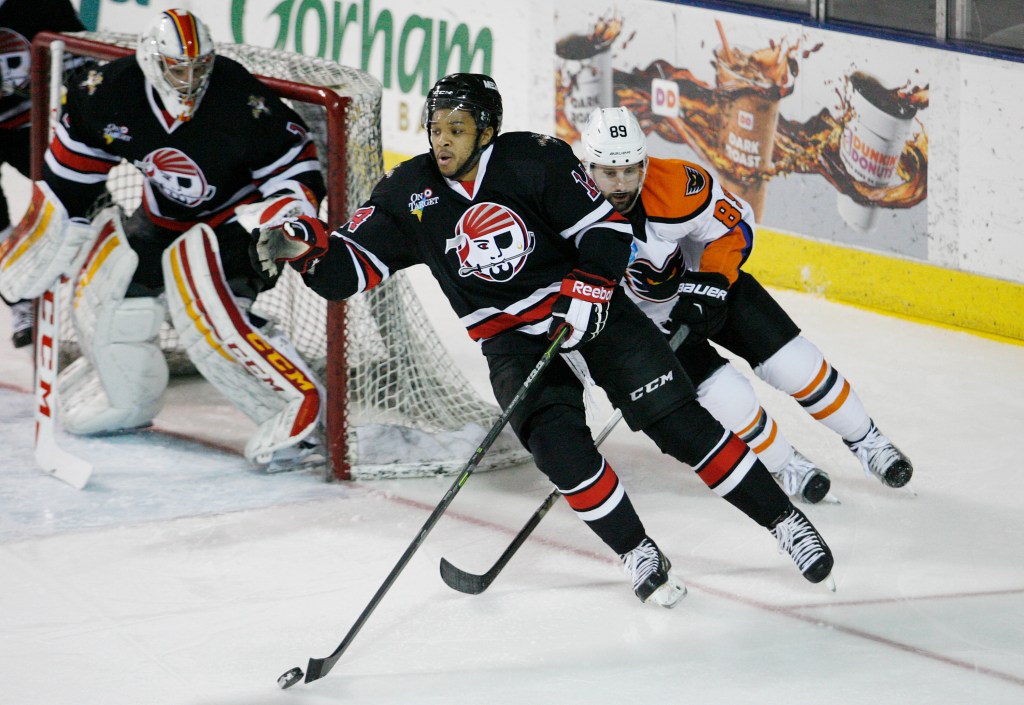 Pirates defenseman Sena Acolatse tries to move puck out of the defensive zone while being pursued by Lehigh Valley’s Sam Gagner. Joel Page/Staff Photographer