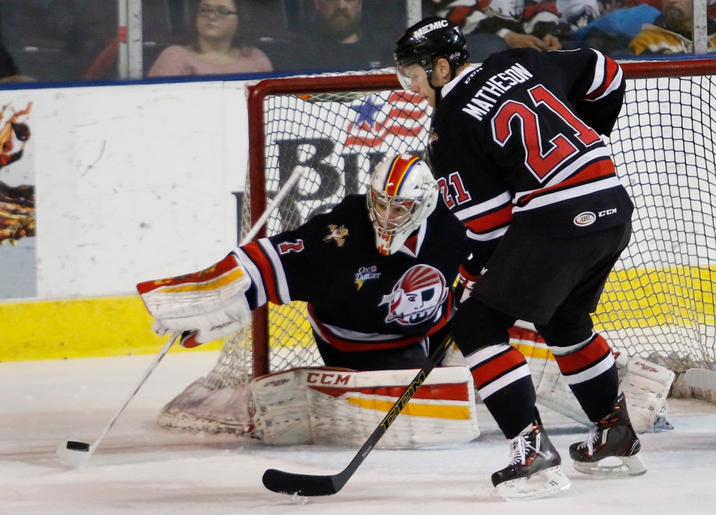 Pirates’ goalie Sam Brittain swats the puck away while defenseman Mike Matheson looks on. Brittain finished with 22 saves. Joel Page/Staff Photographer