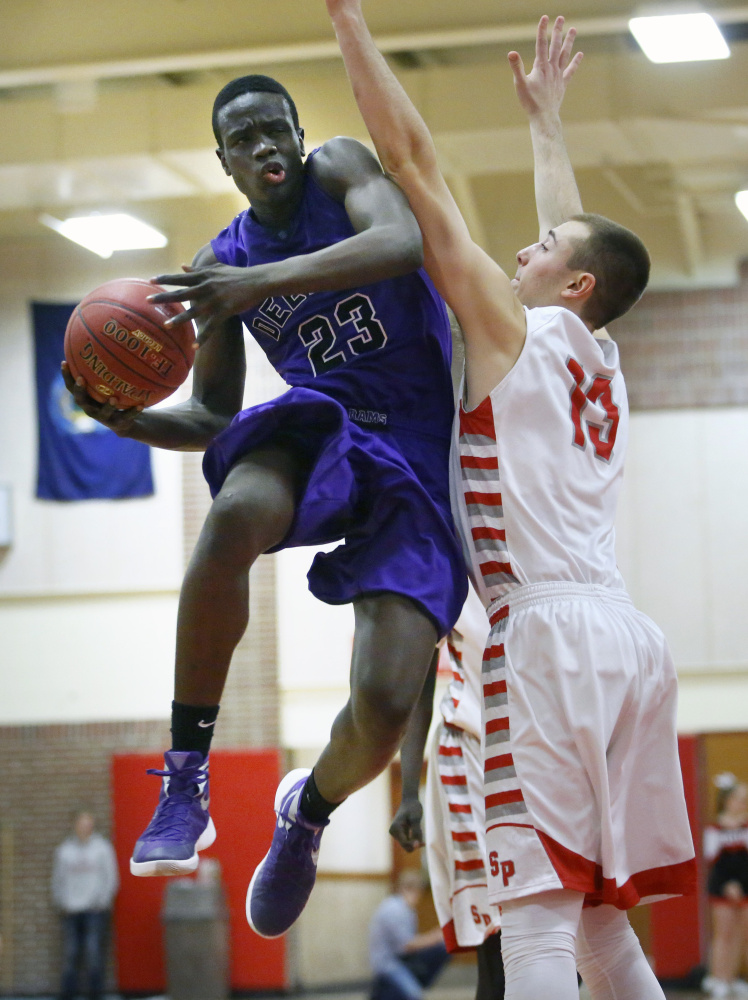 Anthony Lobor of Deering drives to the basket against Jack Fiorini of South Portland during a Class AA basketball game Friday night in South Portland. Lobor had 12 points and 13 rebounds in a 66-46 win.
