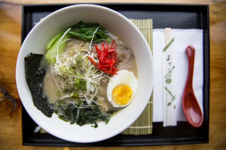 Hakata-style ramen – one of three hot noodle dishes at Ramen Suzikaya – is topped with pork, a soft-boiled egg, pickled ginger and more.