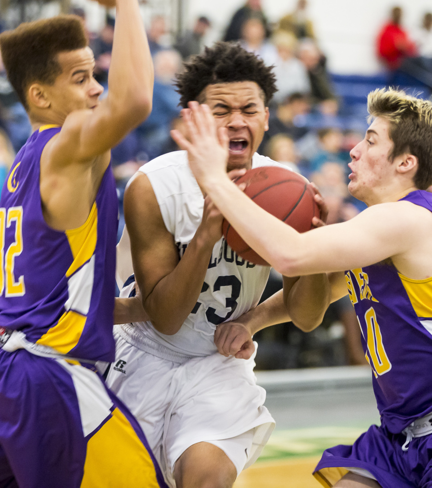 Portland freshman Trey Bellew tries to break through to the basket between Tre Fletcher, left, and Jake Tomkinson of Cheverus during Portland’s 72-42 victory Wednesday night at the Portland Exposition Building.