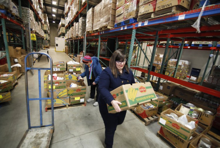 Annie Baker-Streevy, right, pastor at Calvary United Methodist Church in Lewiston, and Pat Gardiner of the Calvary City Mission in Lewiston, collect orders at the Good Shepherd Food Bank in Auburn. “We’re a regular supplier of people’s food,” says Good Shepherd’s president, Kristen Miale. “We’re no longer for emergencies.”