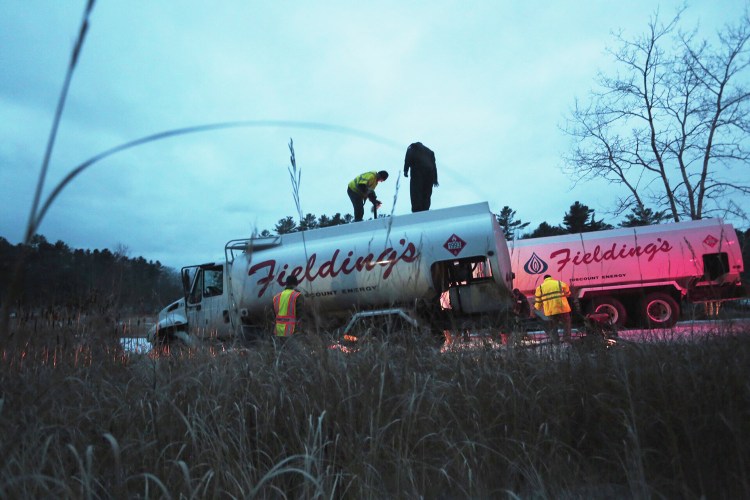 Crews work to clean up at the scene of an oil spill near the Harraseeket River in Freeport on Friday.