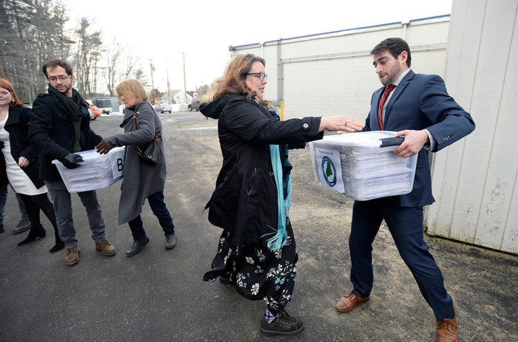 Campaign manager David Boyer passes a box of petitions to Rep. Diane Russell  from Portland as the Campaign to Regulate Marijuana Like Alcohol prepares to deliver the petitions to Augusta Monday, February 1, 2016. 