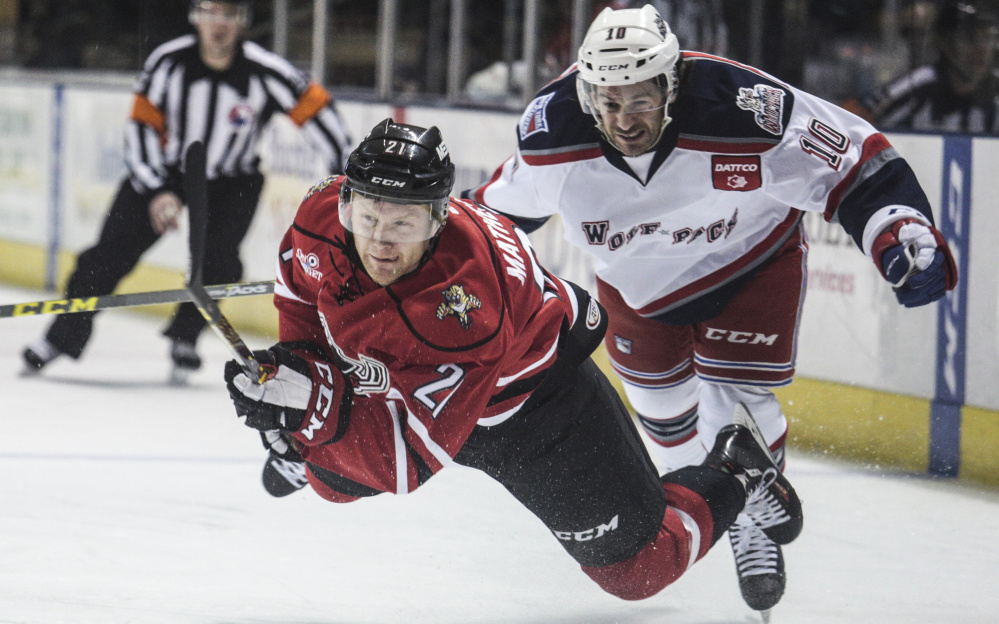 Portland’s Mike Matheson and Hartford’s Brian Gibbons both fall onto the ice as they scramble for the puck.
Photo by Whitney Hayward/Staff Photographer