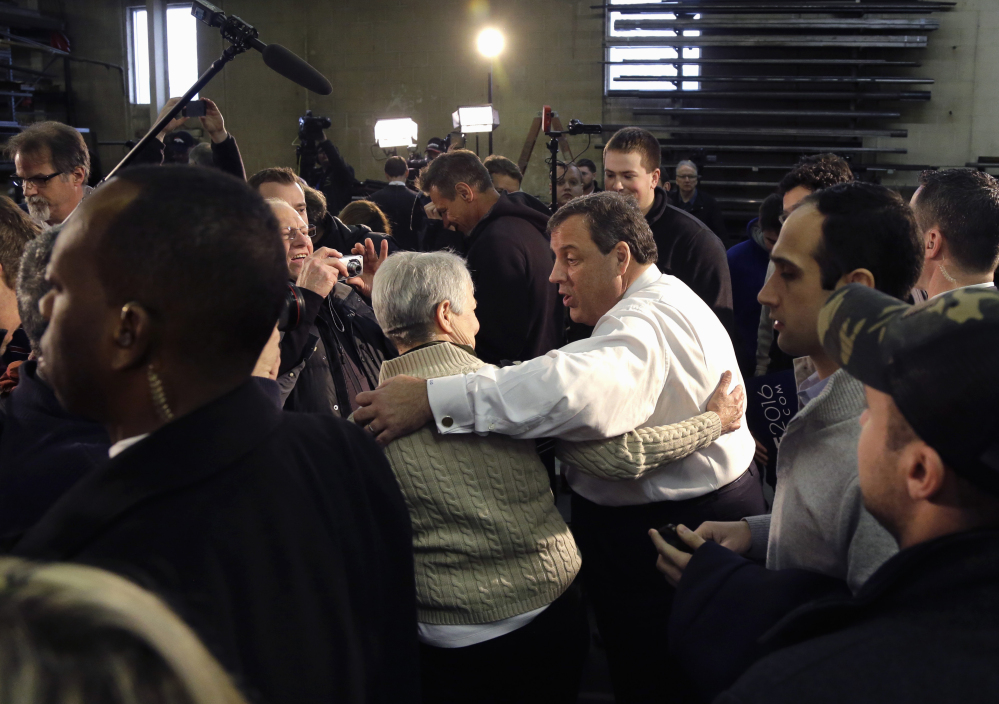 Republican presidential candidate, New Jersey Gov. Chris Christie greets a potential voter after a town hall-style campaign event, Monday in Hudson, N.H.