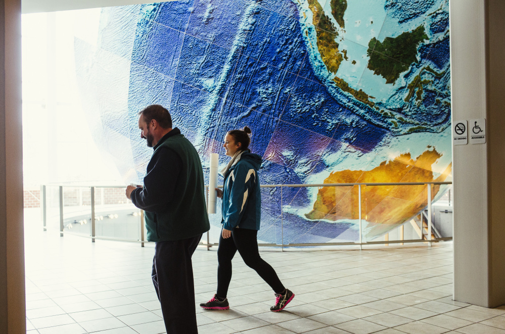 Nicole Cary holds a map of Allagash while walking with Walter Cary inside the lobby of the DeLorme Map Store in Yarmouth. The map store is not part of the Garmin deal, so those employees are expected to lose their jobs.