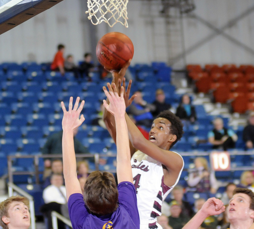 Samatar Iman of Edward Little goes up for a basket over Jack Casale of Cheverus during Thursday’s game at the Augusta Civic Center. Edward Little won the game, 46-43.