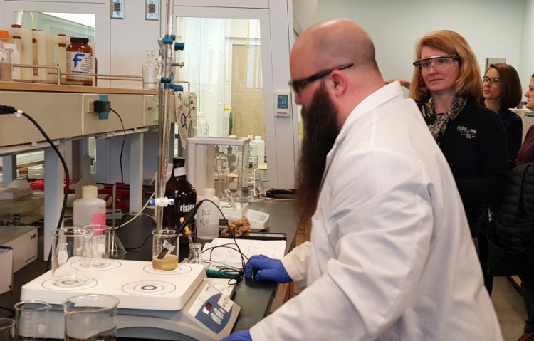 Ryan Michaud, a University of Southern Maine student, checks acidity levels in a Rising Tide beer as Rising Tide Brewing Co. co-owner Heather Sanborn watches on Thursday morning.