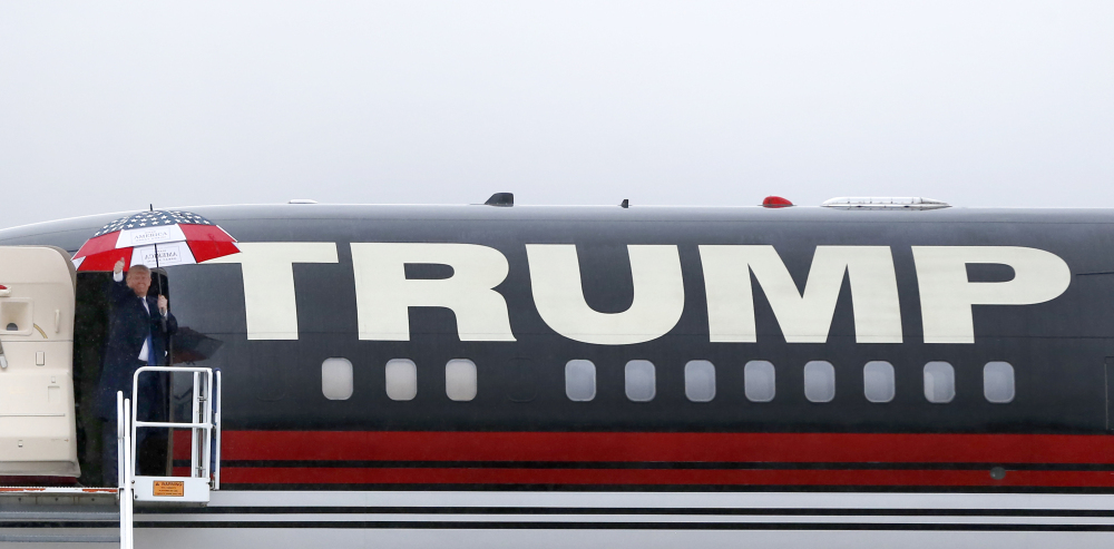 Republican presidential candidate Donald Trump waves to the crowd as he leaves a rally in Bloomington, Ill.