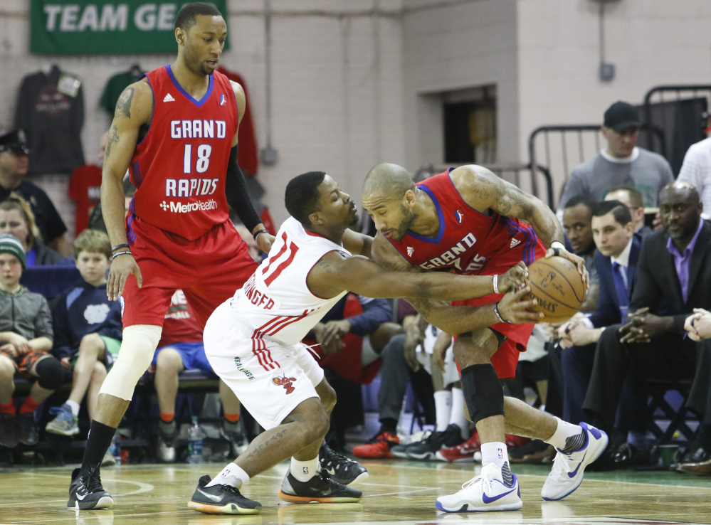 Andre Stringer reaches for the ball from Dahntay Jones while Kam Holsey watches play in the first half in Portland. Jill Brady/Staff Photographer