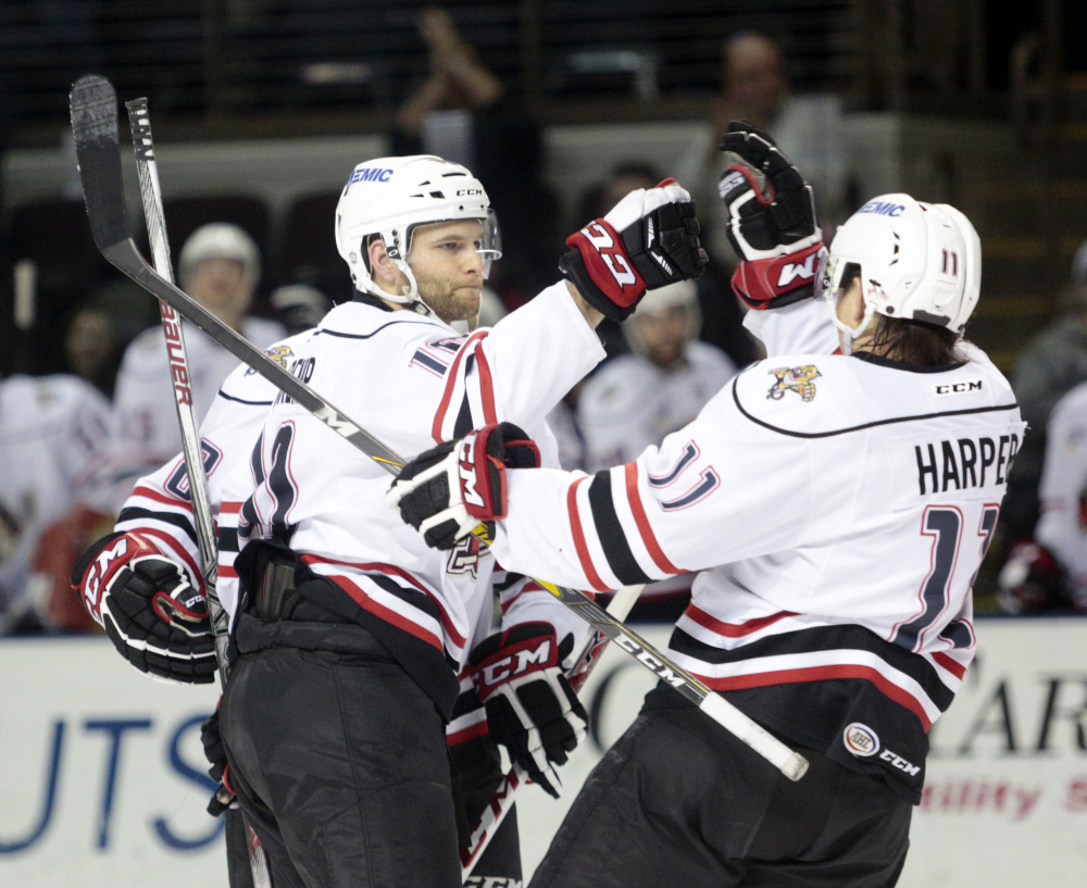 Rob Schremp of the Portland Pirates celebrates with teammate Shane Harper, right, after scoring in the second period of a 6-3 win over Bridgeport on Wednesday night at the Cross Insurance Arena in Portland.