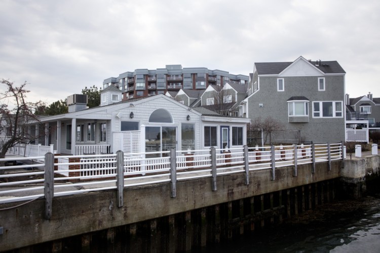City councilors approved a proposal this week for a new upscale restaurant to replace the former Joe’s Boathouse, left, next to the Breakwater condominiums in South Portland. The project faces additional review hurdles.