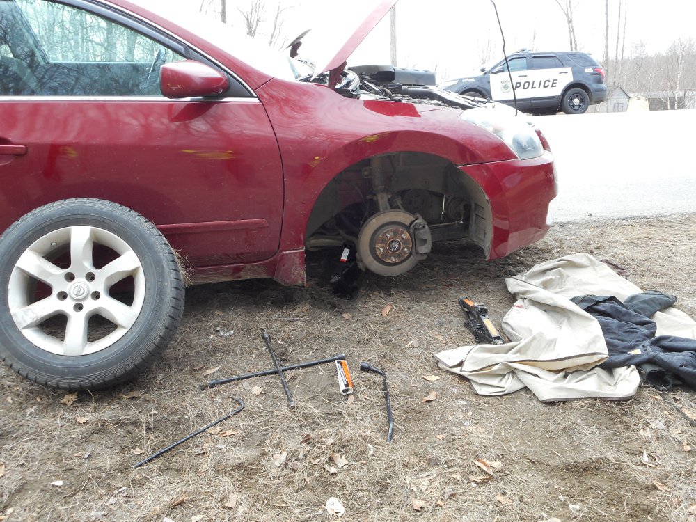 A 2008 Nissan sedan is seen on North Belfast Avenue in Augusta Monday morning after it fell on top of Carroll Cummings, 69, who had jacked the car up to fix something underneath. Contributed photo