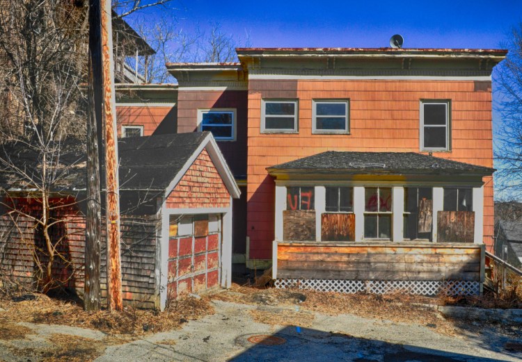 Windows are boarded up Tuesday at 15 Morton Place in Augusta, a practice that would be banned if the City Council approves a proposed new ordinance.