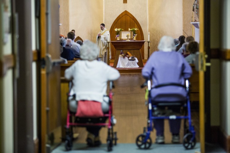 Rev. Paul Dumais steps away from the altar after celebrating Holy Thursday Mass at the d'Youville Pavillion at St. Mary's Hospital in Lewiston.